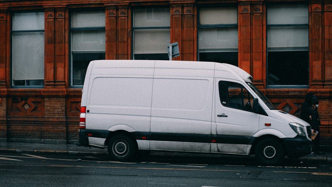 White delivery van parked beside a road, illustrating regional courier service.